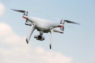 white UAV with camera flying in Connecticut blue sky